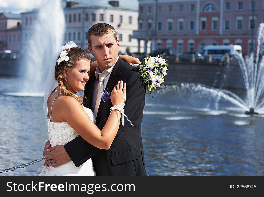 Bride and groom and fountains in river on wedding walk. Bride and groom and fountains in river on wedding walk
