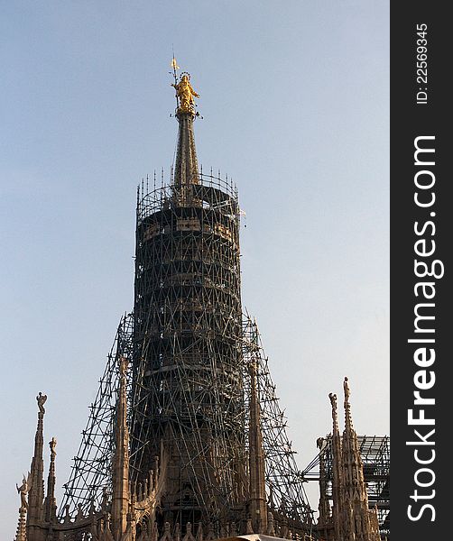 Renovation of  the main spire of the cathedral,  the dome of Milan with the golden statue of Madonnina. Renovation of  the main spire of the cathedral,  the dome of Milan with the golden statue of Madonnina.
