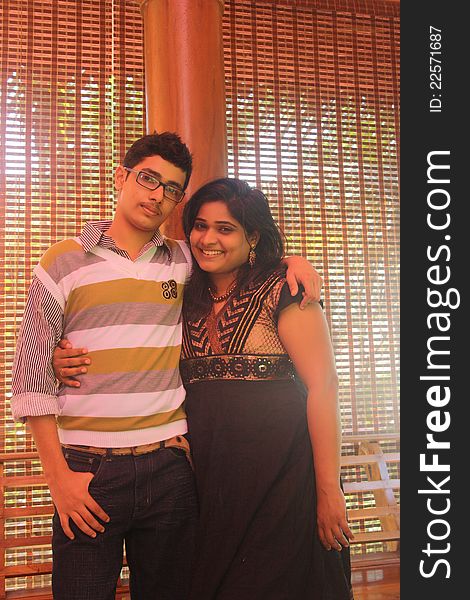 Indian Brother and Sister Happily Hugging in a nice studio indoor.