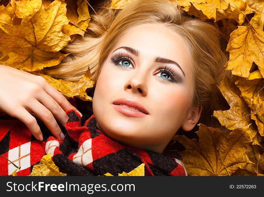 The beautiful blonde lies in autumn foliage