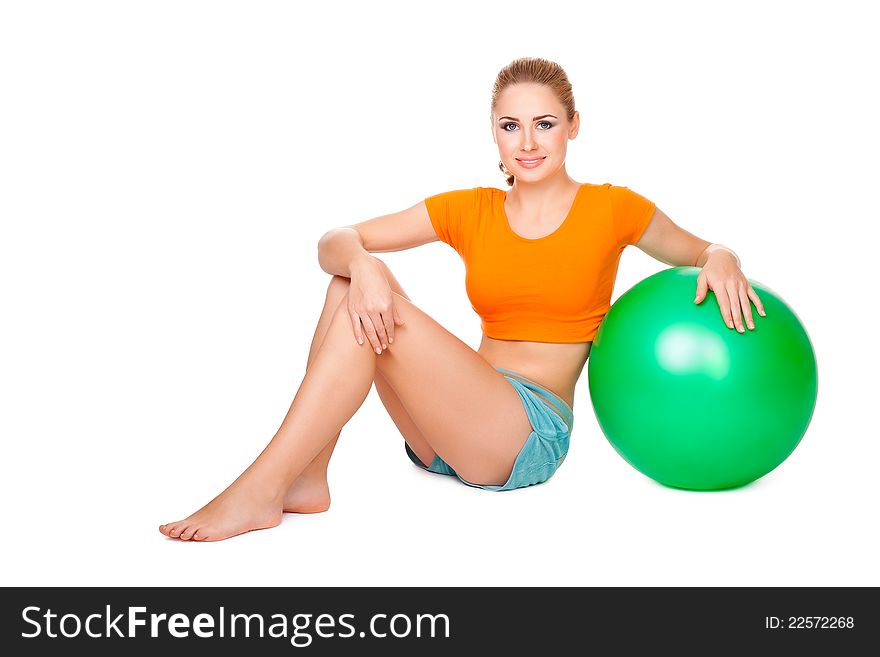 Pretty blond girl making sport with a ball isolated on a white background