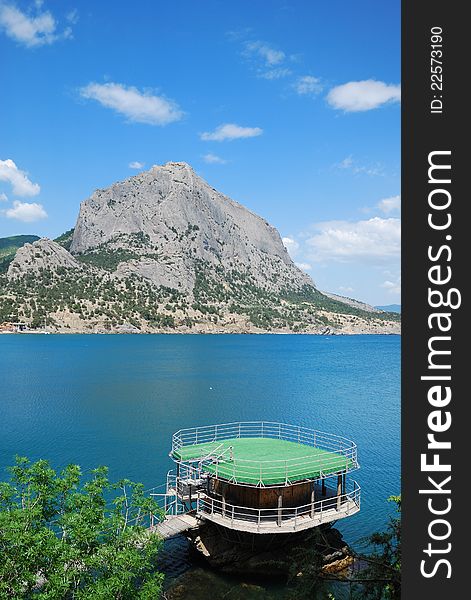 Mountain Sokol together with cape Hoba-Kaya have formed the Green bay of Novij Svet. In the foreground there is a fishing platform. Mountain Sokol together with cape Hoba-Kaya have formed the Green bay of Novij Svet. In the foreground there is a fishing platform.