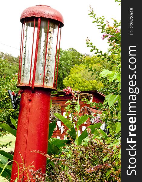 Antique Red Gas Pump Sitting Near A Shed