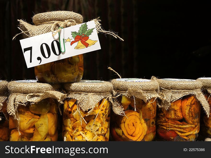 Bottled cheeses in oil vith vegetables and spices. With price tag on top bottle as displayed on christmas market booth