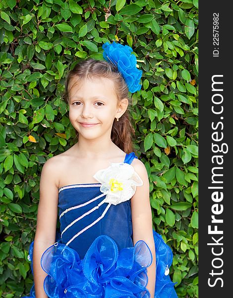 Portrait of a beautiful girl with long hair and blue bow in festive dress. Portrait of a beautiful girl with long hair and blue bow in festive dress