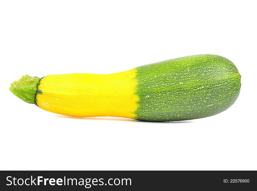 A hybrid green and golden zucchini on a white background
