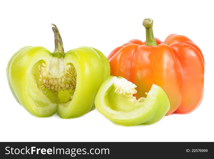 A red and a cut green bell pepper on a white background. A red and a cut green bell pepper on a white background