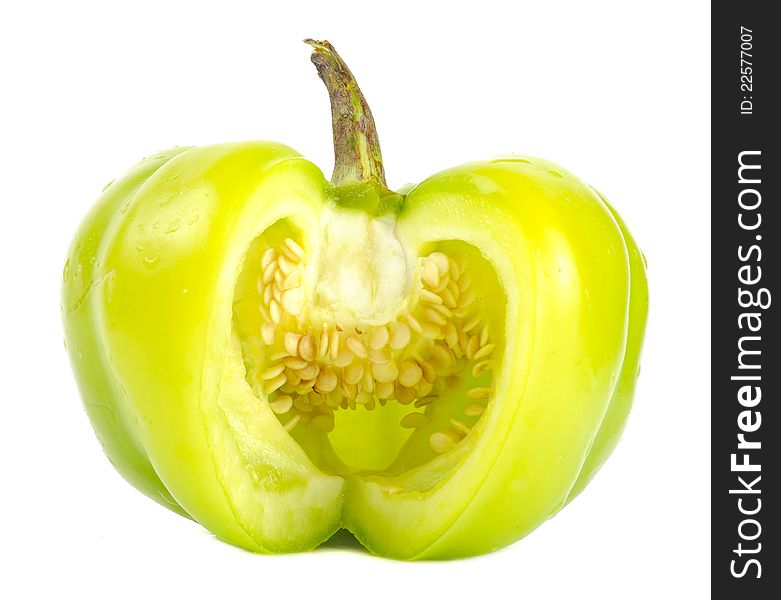 A cut green bell pepper with seeds on a white background