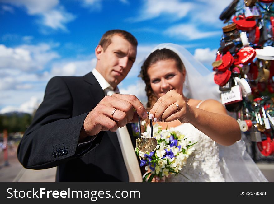 Happy bride and groom with padlock