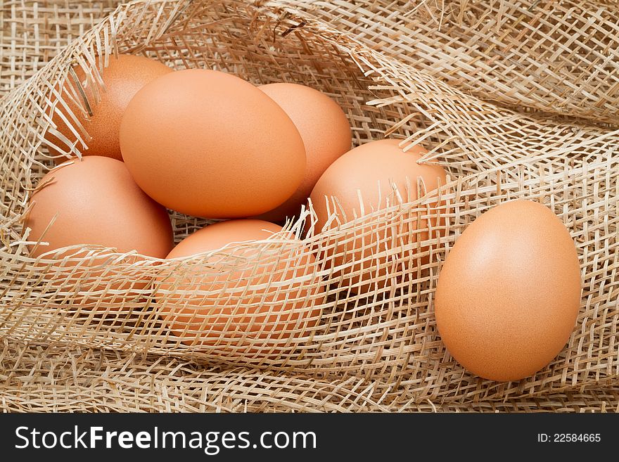 Seven brown eggs on burlap fabric