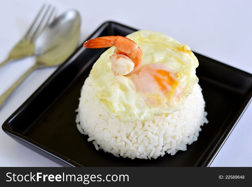 A delicious fried egg and prawn on steamed rice. A delicious fried egg and prawn on steamed rice