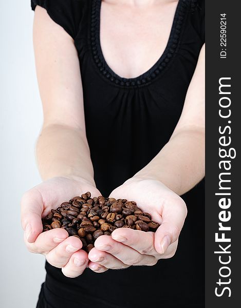 Woman holding hands in coffee beans, isolated