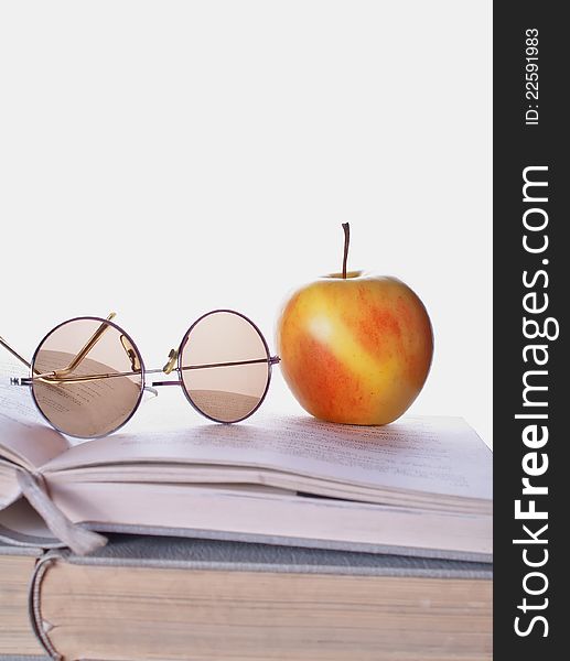 Composition with book and apple on the wooden table