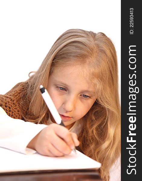 Schoolgirl doing homework, lessons, writes in a notebook, school. Schoolgirl doing homework, lessons, writes in a notebook, school