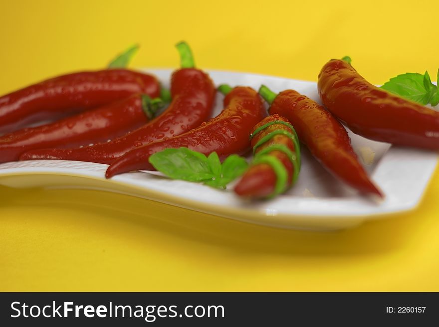 Red chili with oregano on the yellow background