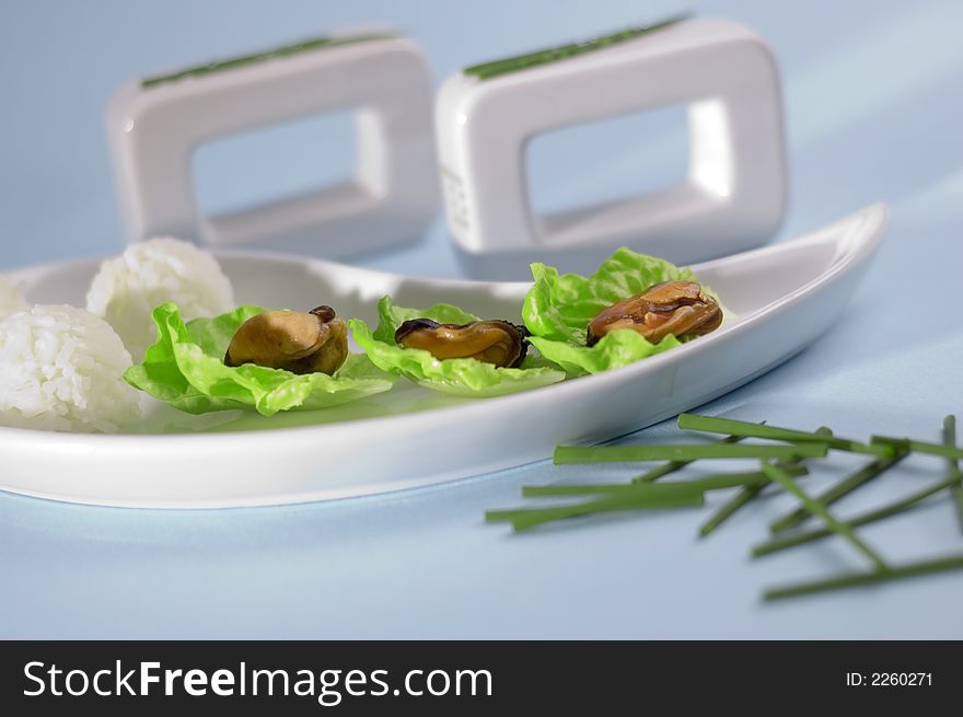 Shells with salad and rice on the blue background