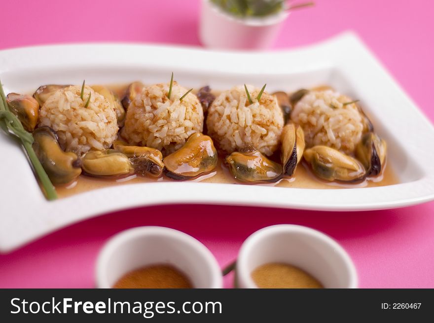 Shells with rice and green onion on the pink background