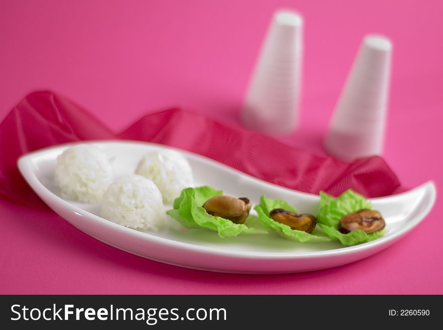 Shells with rice and salad on the pink background