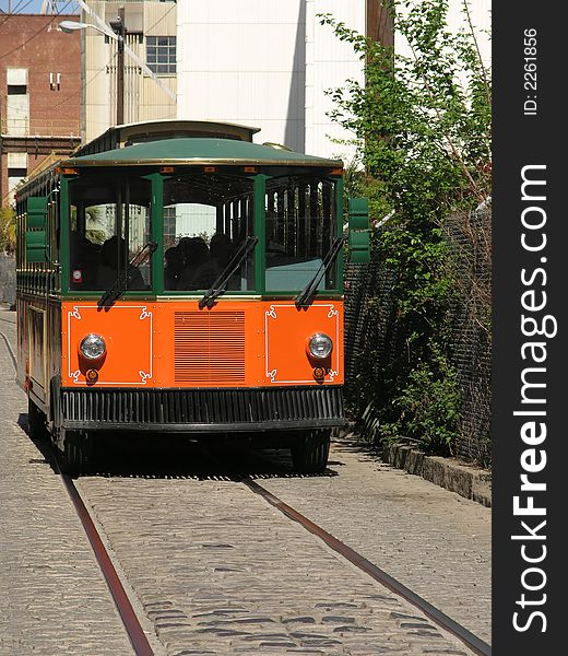 Orange and black Trolley Tour bus on cobblestone street