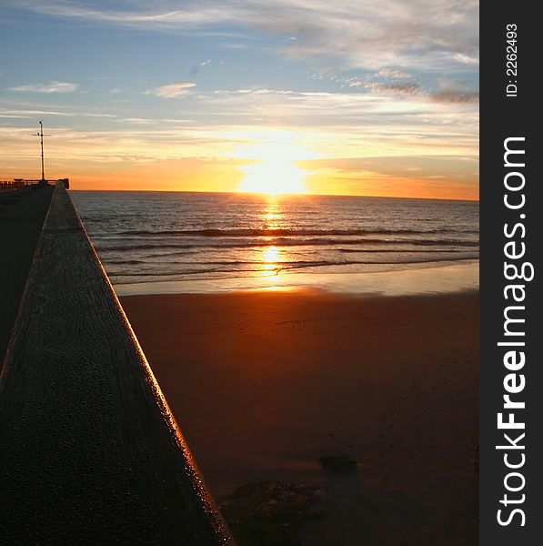 Sun rising on the beach an the pier. Sun rising on the beach an the pier