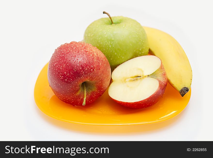 Red both green apples and banana on a yellow plate