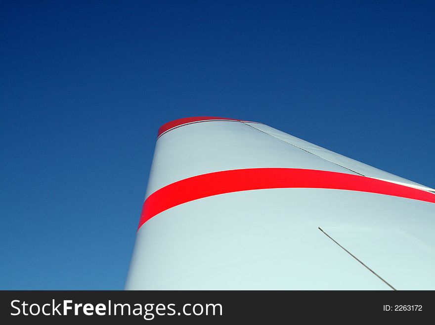 Wing with orange stripes against blue sky