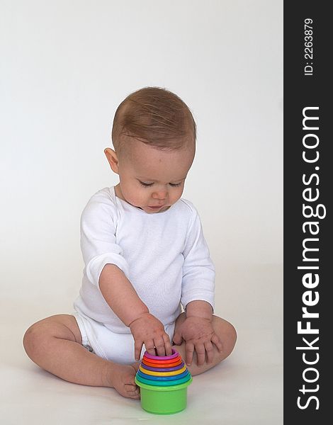 Image of adorable baby playing with stacking cups. Image of adorable baby playing with stacking cups