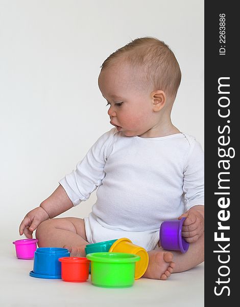 Image of adorable baby playing with stacking cups. Image of adorable baby playing with stacking cups