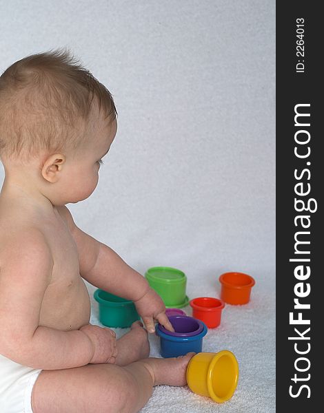 Image of adorable baby playing with stacking cups. Image of adorable baby playing with stacking cups