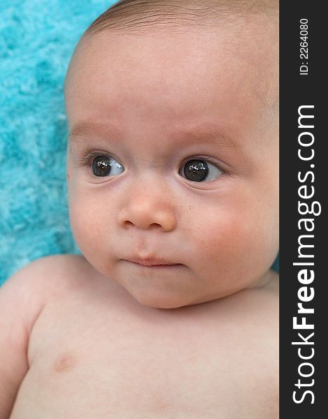 Image of beautiful 6 month old baby boy lying on a fuzzy turquoise blanket. Image of beautiful 6 month old baby boy lying on a fuzzy turquoise blanket