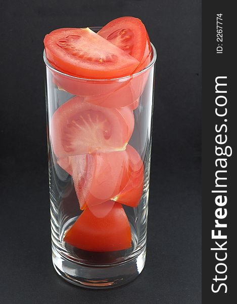Tomato in the glass on the black
