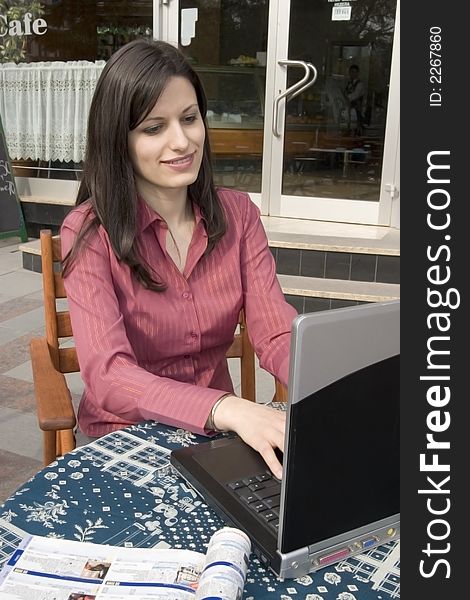 Businesswoman sitting in cafe and working on laptop