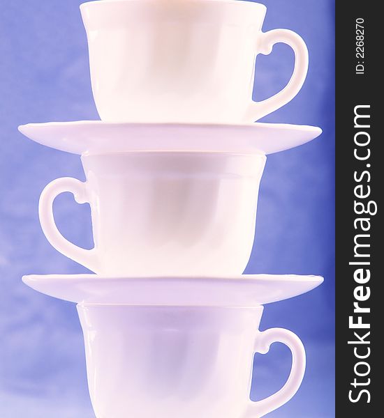 Pure white cups on  blue background, close up