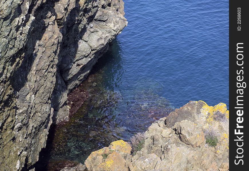 A blue and transparent sea between the rocks on the coast