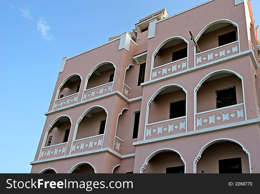Pink stucco apartment building in tropical area. Pink stucco apartment building in tropical area