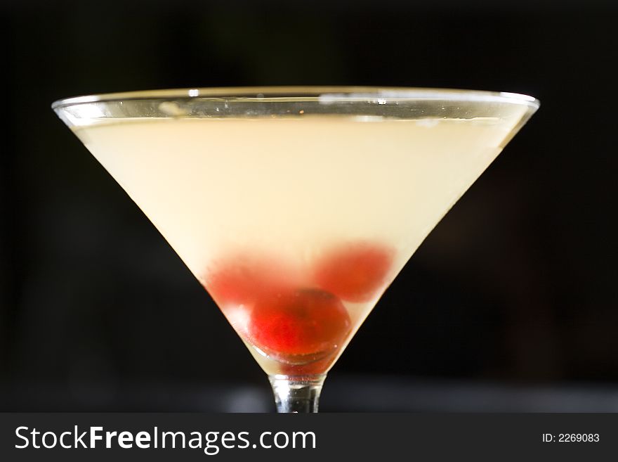 An isolated martini cocktail glass with cherries. An isolated martini cocktail glass with cherries