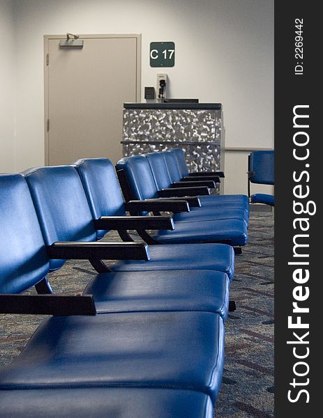 A row of sits leading towards a closed gate at the airport. A row of sits leading towards a closed gate at the airport.