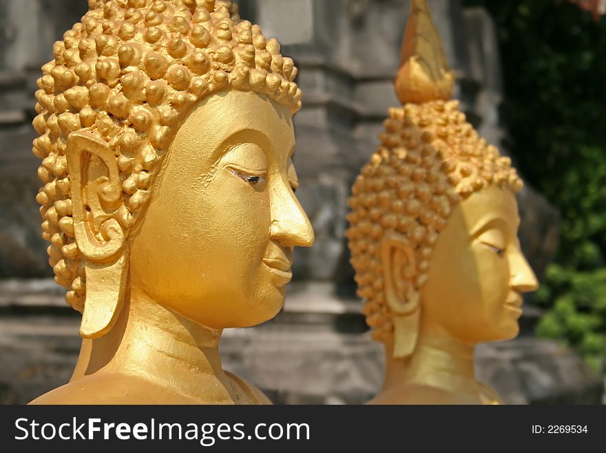 Close up of two buddhist statue heads with selective focus