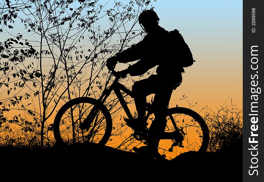 Mountain biker silhouette with orange sunrise