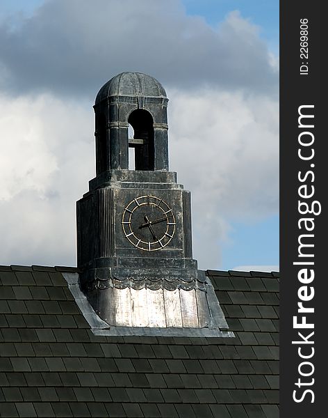 An old clock tower on the top of a roof.