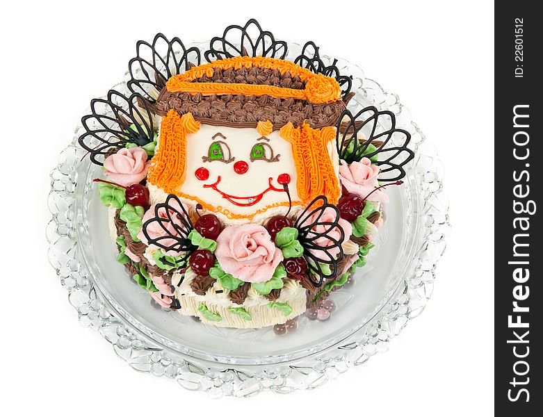 Delicious cake with a pattern in the form of little faces clown on a transparent plate. Delicious cake with a pattern in the form of little faces clown on a transparent plate