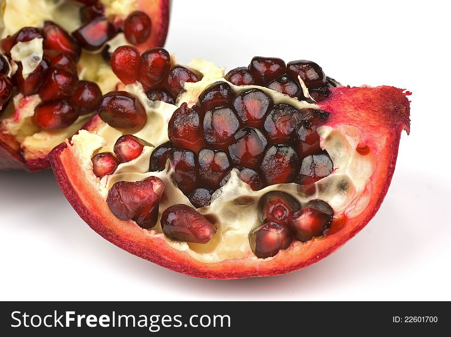 Juicy pomegranate and its half with leaves. Isolated on a white background