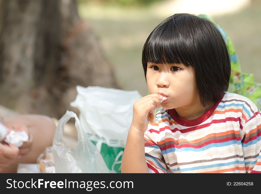 Asian Little Girl eating, picnic with family outdoor. Asian Little Girl eating, picnic with family outdoor