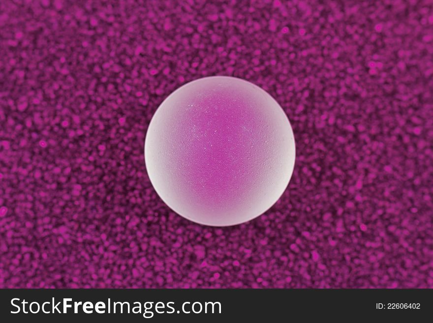Polished glass ball on a soft purple carpet