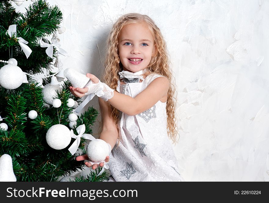 Cute blonde girl and Christmas tree with white decoration. Cute blonde girl and Christmas tree with white decoration
