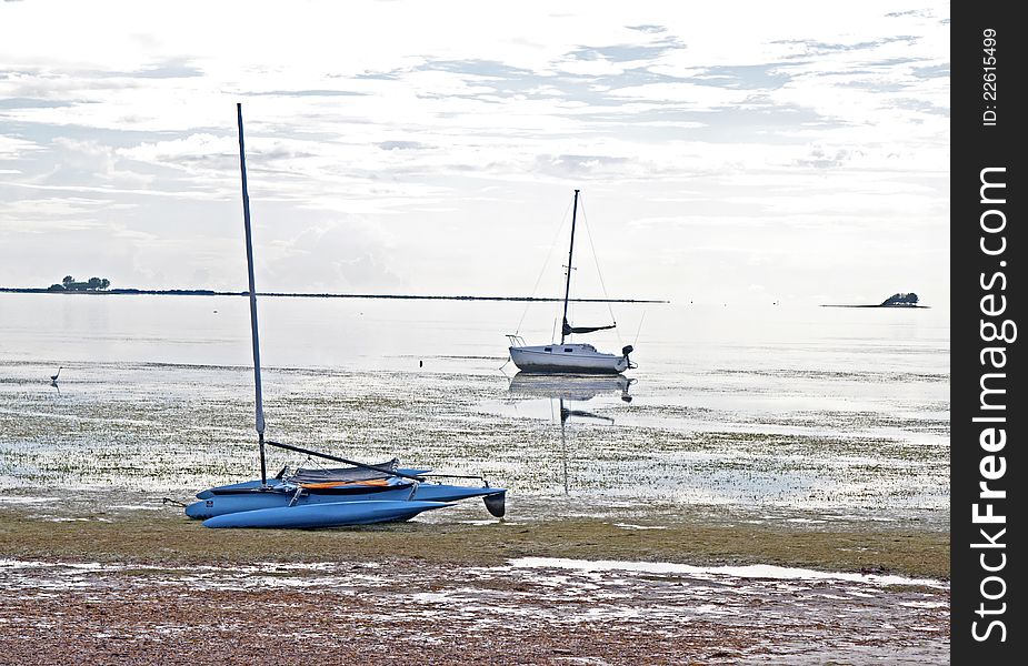 Two boats stranded in shallow water on an overcast day. Crystal Beach, Florida. Two boats stranded in shallow water on an overcast day. Crystal Beach, Florida.