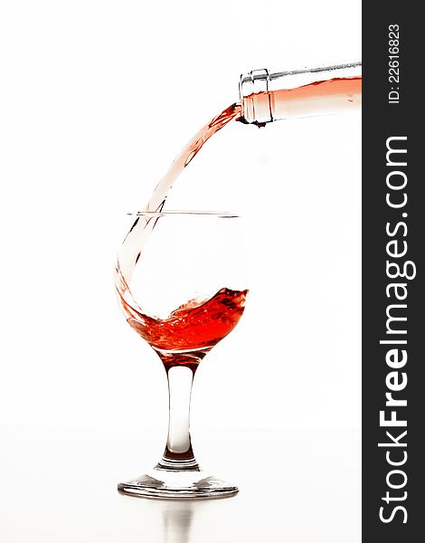 Pouring rose wine in glass isolated on white background. Pouring rose wine in glass isolated on white background