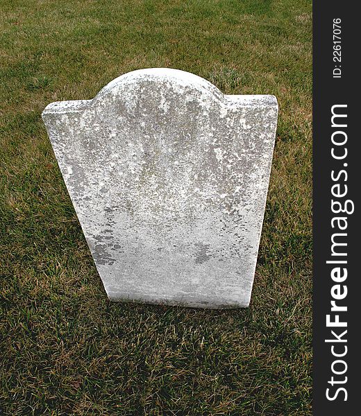 Old, plain, weathered, unmarked vintage marble headstone with a grass background. Old, plain, weathered, unmarked vintage marble headstone with a grass background.