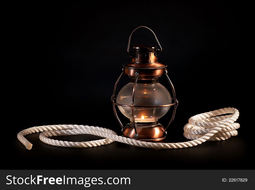 Old lamp and rope on black background