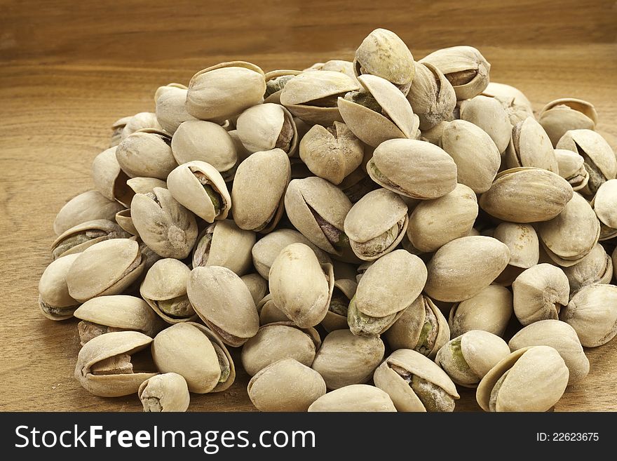 Roasted Pistachio nuts on a wood background. Roasted Pistachio nuts on a wood background